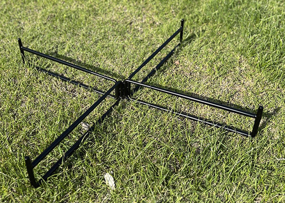 Black metal garden rake on grass