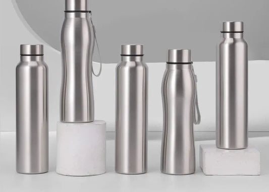 Set of silver stainless steel water bottles on a light gray background
