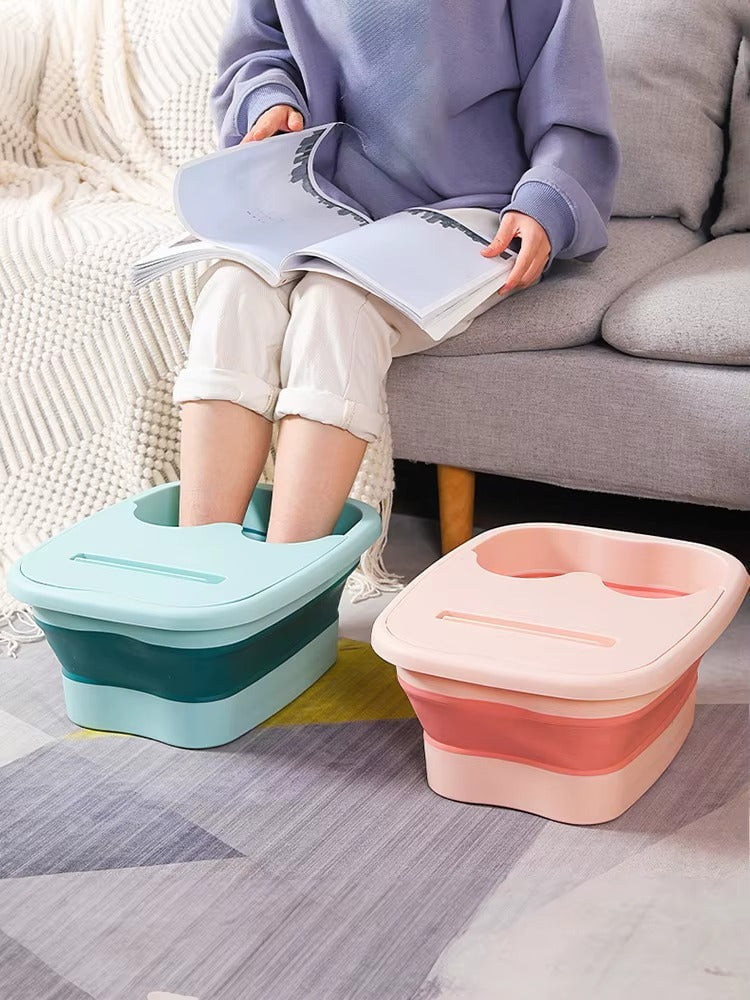 "A blue and white foldable foot bath massage bucket shown in its expanded state, featuring built-in massage rollers at the base and a sturdy carry handle. Ideal for home pedicures and portable foot soaking."