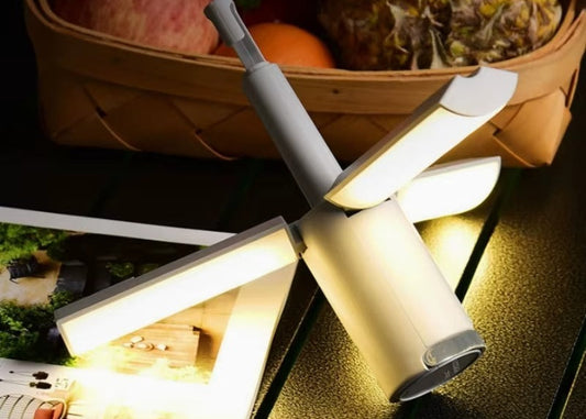 Foldable LED lamp on a table with a basket of fruit in the background