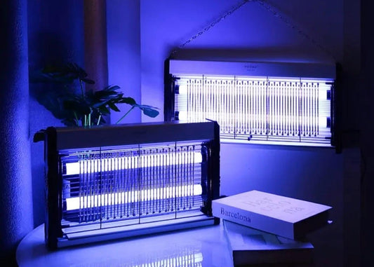 Two insect zappers emitting a blue light in a dark room.