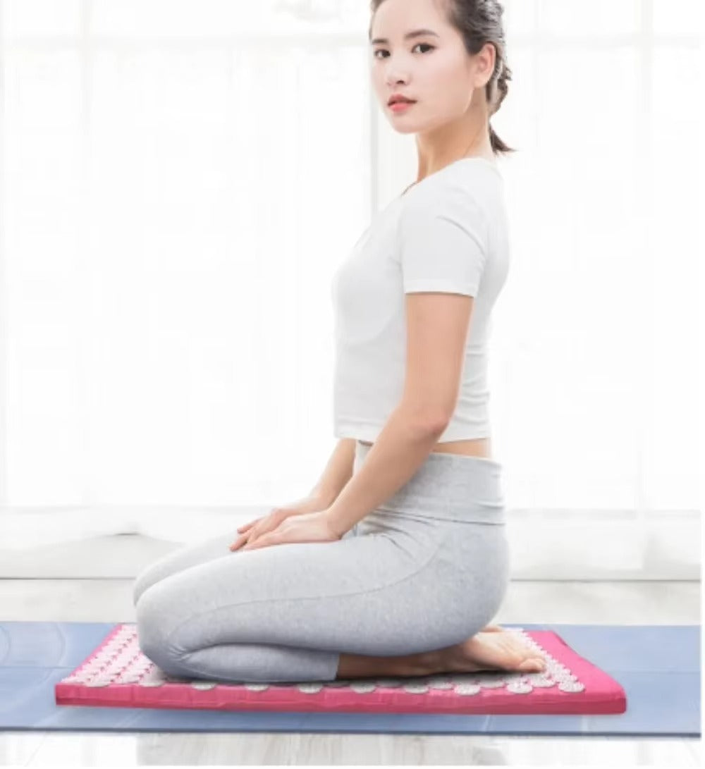 A person lying on the CORECOM® spike mat to relieve chronic back and shoulder tension.