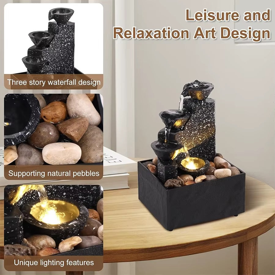 Compact indoor waterfall fountain placed on a modern office desk next to a laptop to help reduce work stress.